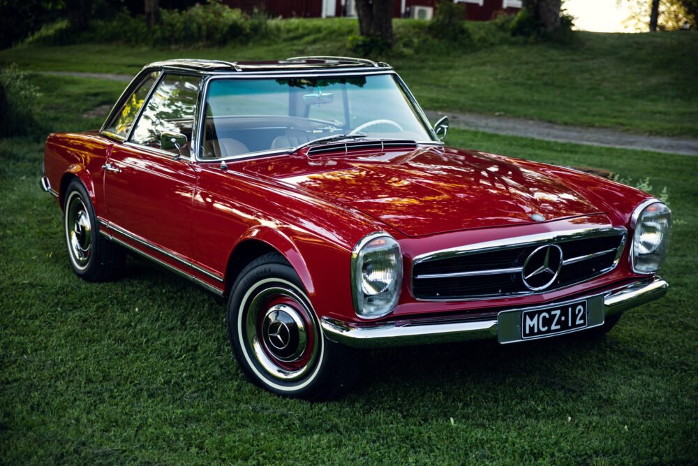 Red vintage Mercedes convertible parked on grass