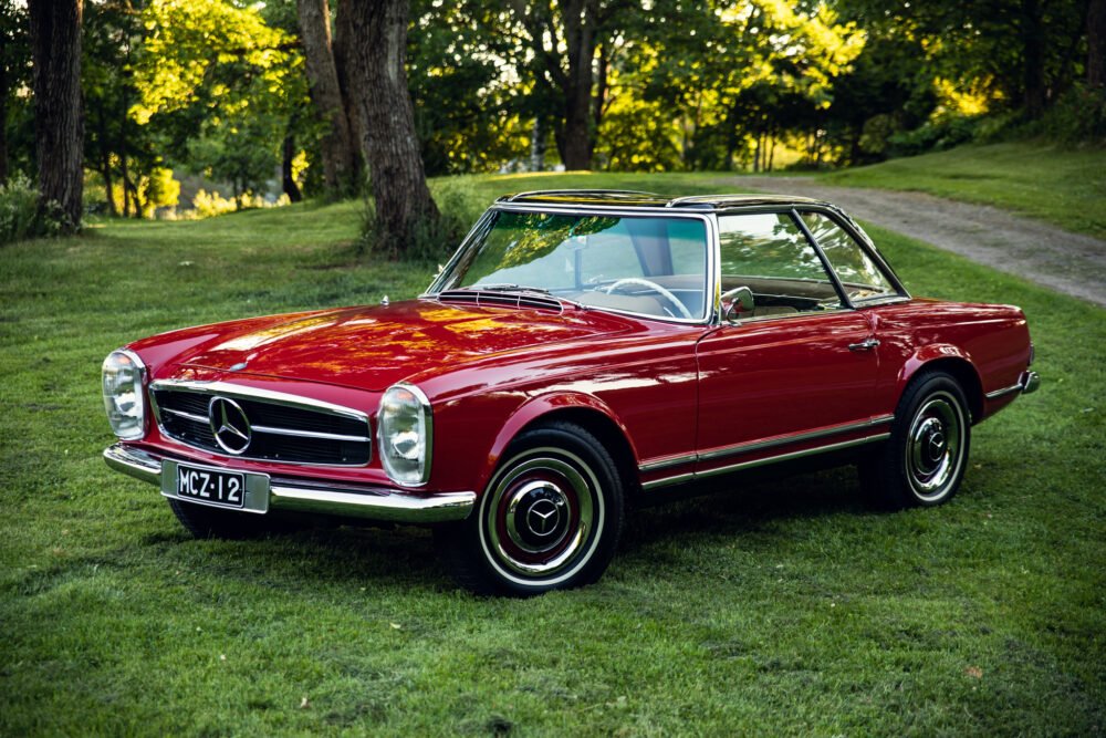 Vintage red Mercedes-Benz parked in green park.