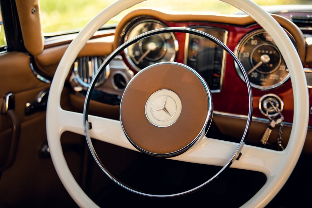 Vintage Mercedes dashboard and steering wheel, close-up view.