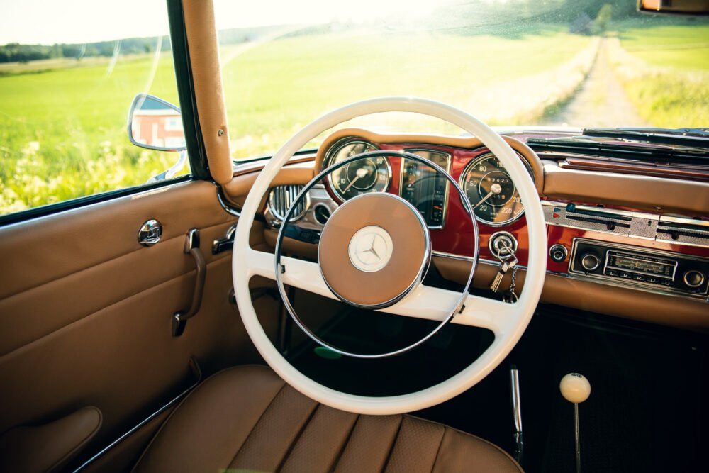 Vintage Mercedes dashboard, country road view.