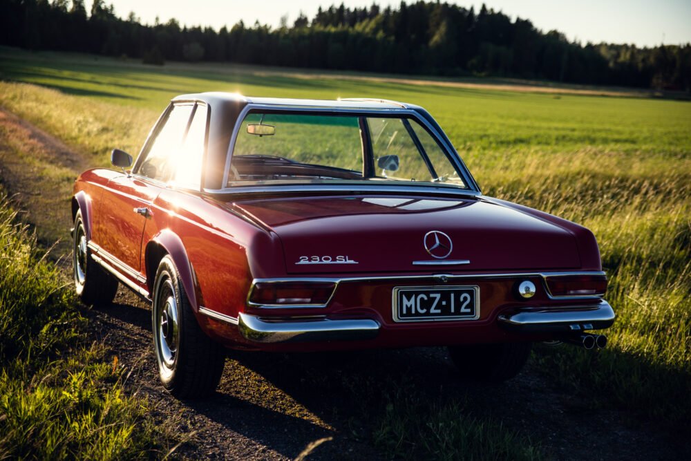 Vintage Mercedes 230SL on country road at sunset.