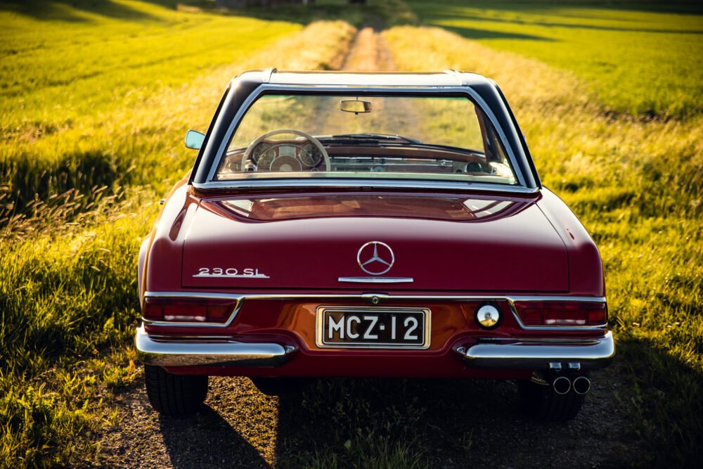 Vintage Mercedes 280SL parked on a country road.