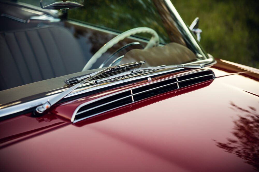Close-up of vintage car hood and windshield.