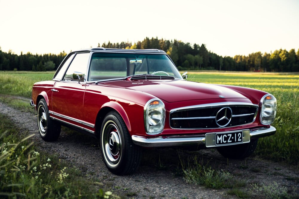 Red vintage Mercedes-Benz convertible in countryside setting