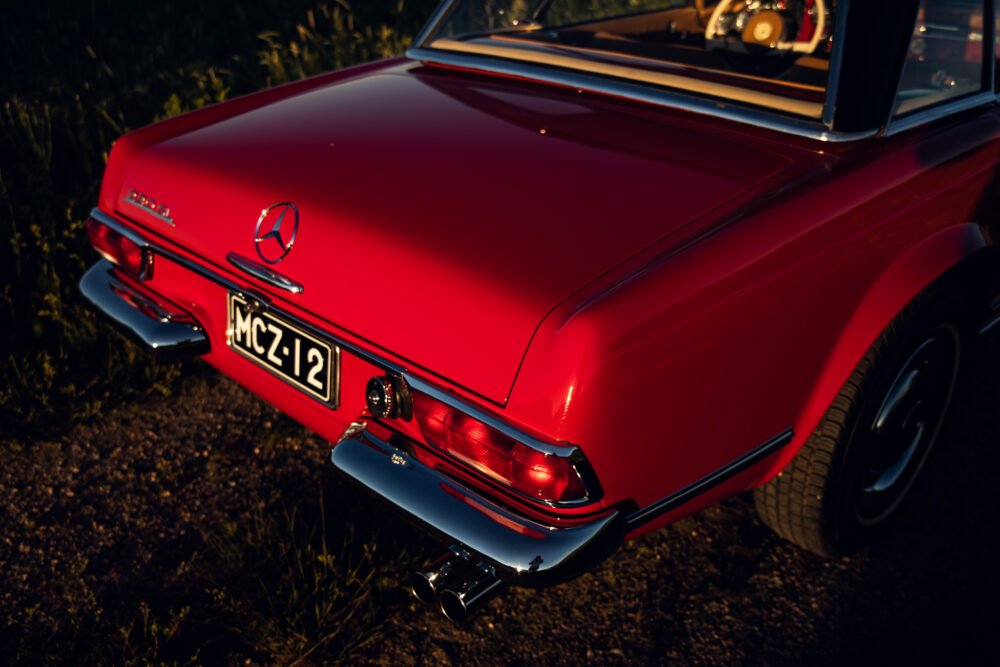 Vintage red Mercedes convertible at sunset.