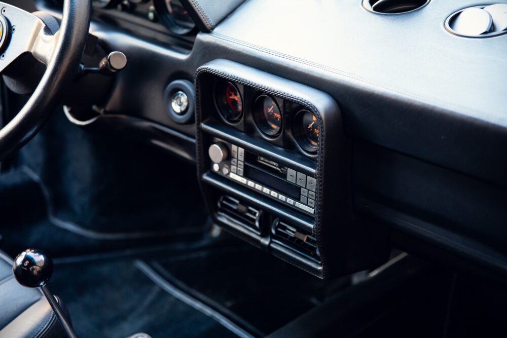 Classic sports car dashboard with gauges and controls.