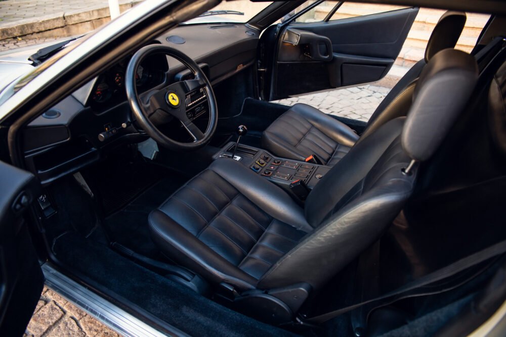 Ferrari interior with steering wheel and leather seats.