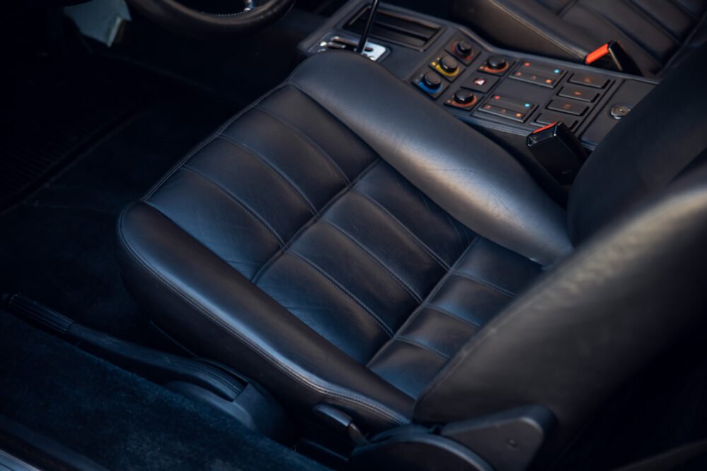 Black leather car seat with modern controls.
