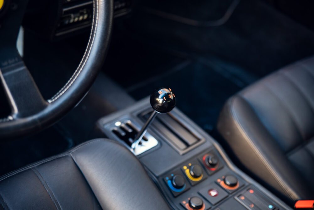 Manual transmission gear shift in car interior.