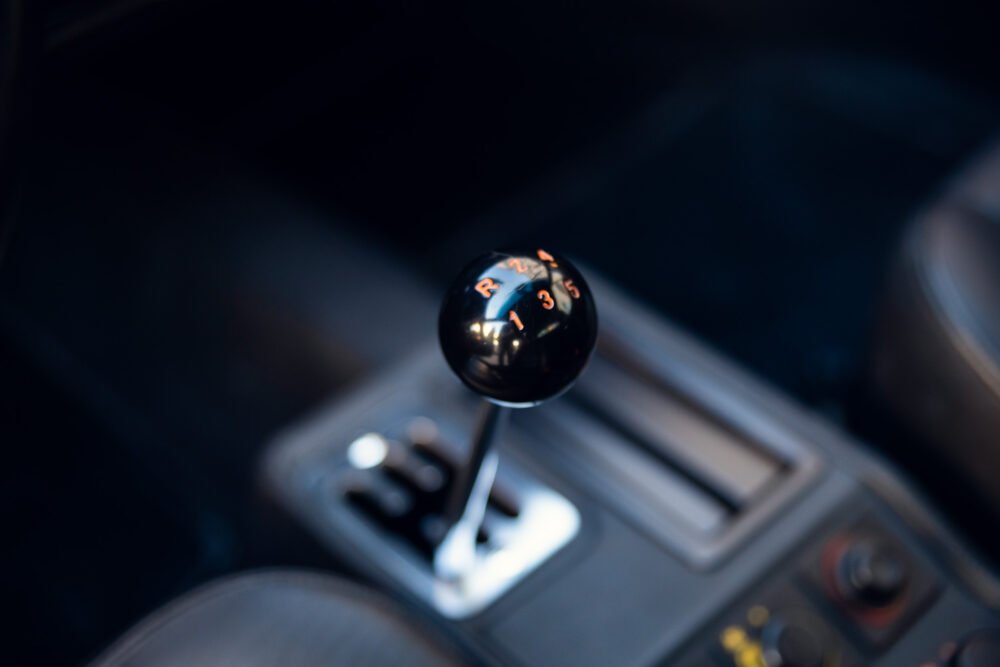 Close-up of manual transmission gear shift in car.