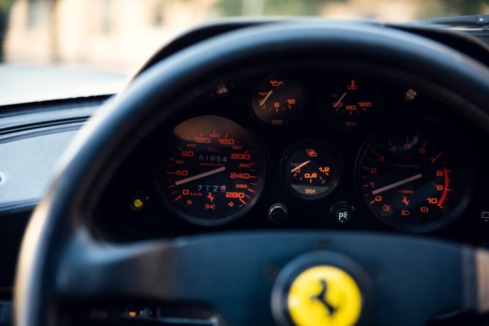 Classic Ferrari dashboard gauges close-up.