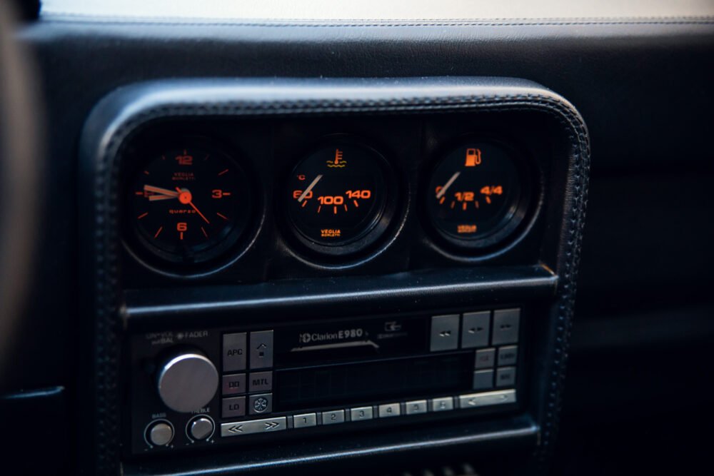 Car dashboard with vintage gauges and audio system.