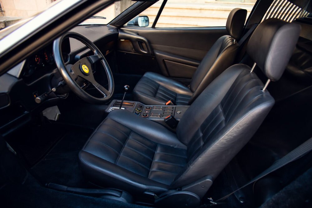 Interior of a classic black sports car with leather seats.