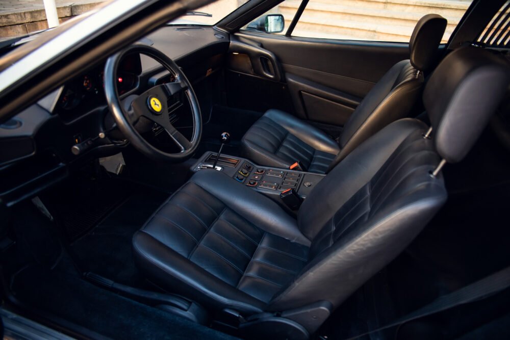 Black leather interior of a sports car with manual transmission.