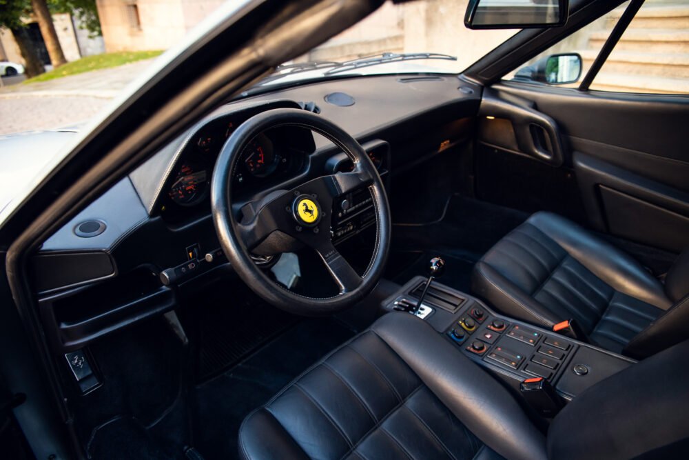 Interior of a classic Ferrari with leather seats.