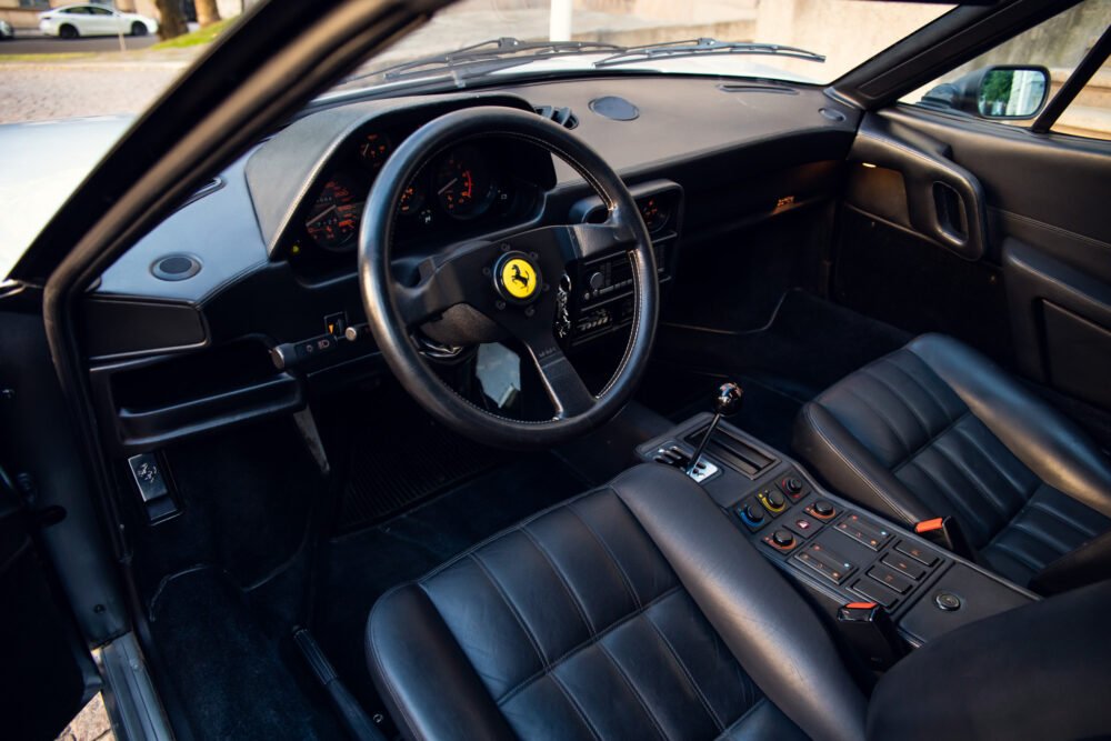 Interior view of a Ferrari with steering wheel visible.