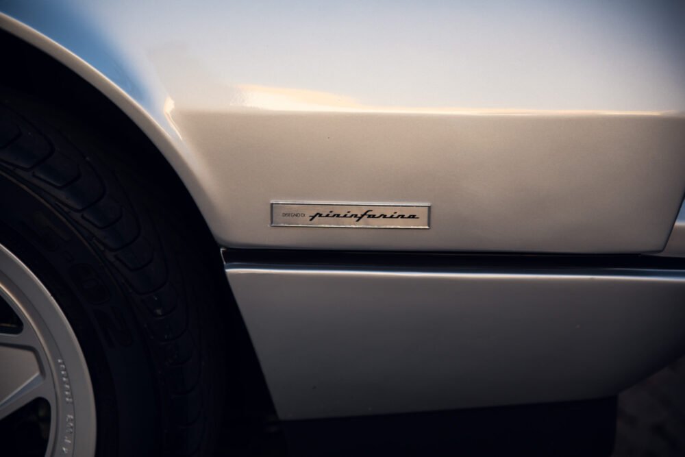 Pininfarina logo on car's fender close-up.