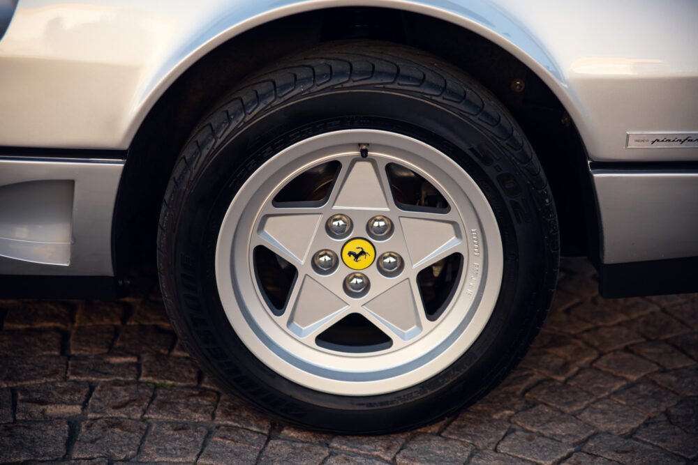 Close-up of white sports car wheel with logo.