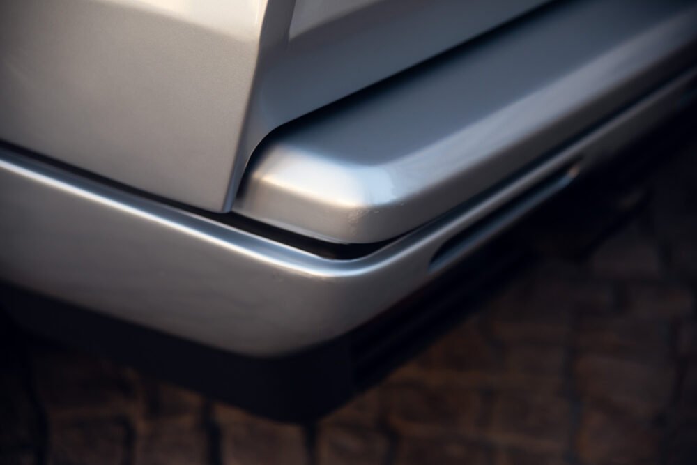 Close-up of silver car bumper detail.