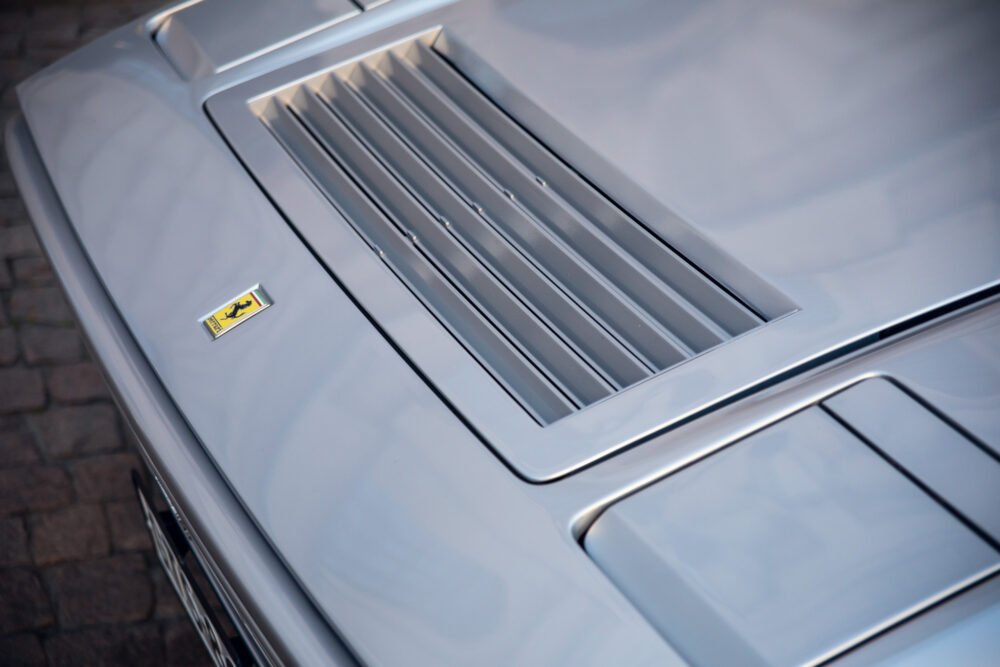 Close-up of silver Ferrari hood and logo.