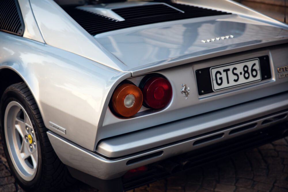 Silver Ferrari rear view, tail lights visible.