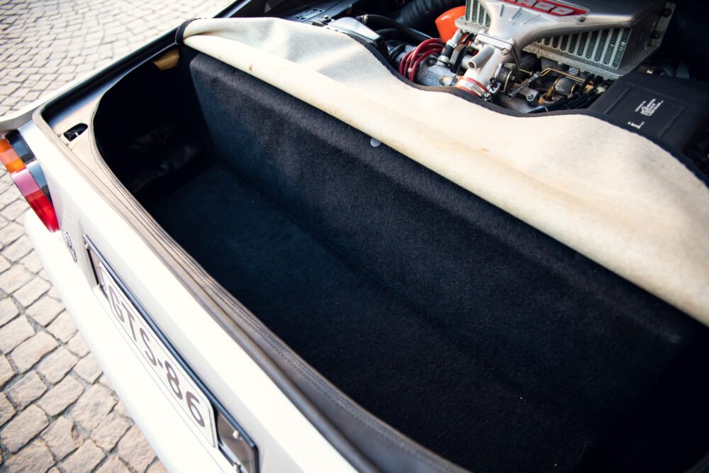Open car trunk displaying engine and custom modifications.