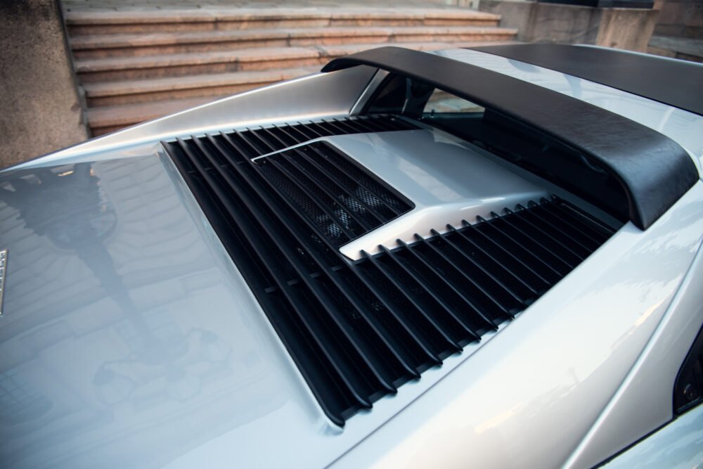 Close-up of sports car's rear wing and engine vents.