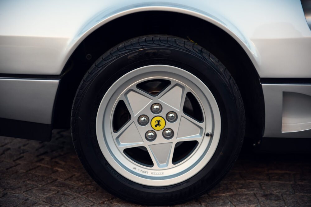Close-up of car wheel with distinctive logo.