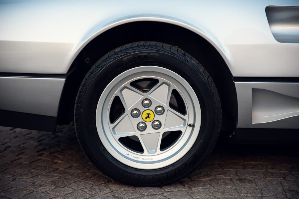 Close-up of Ferrari car wheel with logo.