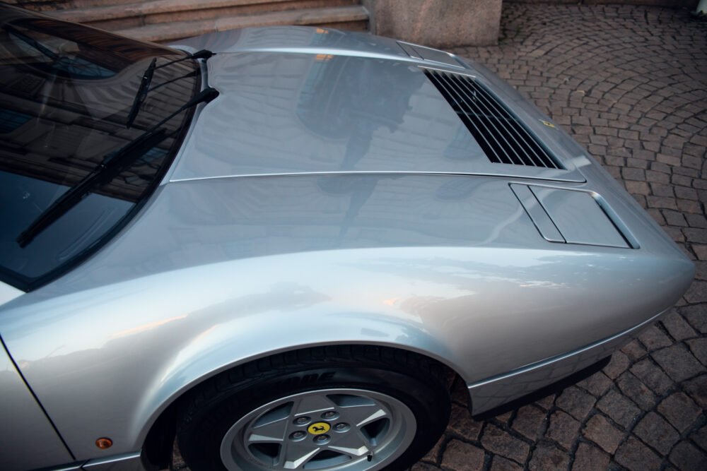 Silver sports car with visible hood and wheel.