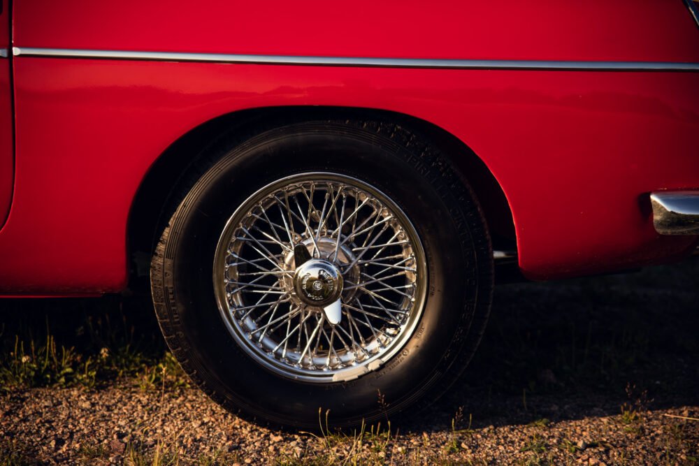 Red vintage car wheel with chrome spokes.