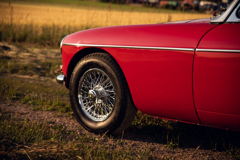 Red vintage car close-up in a field.