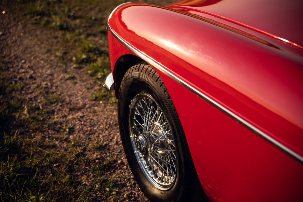 Red vintage car's wheel close-up.