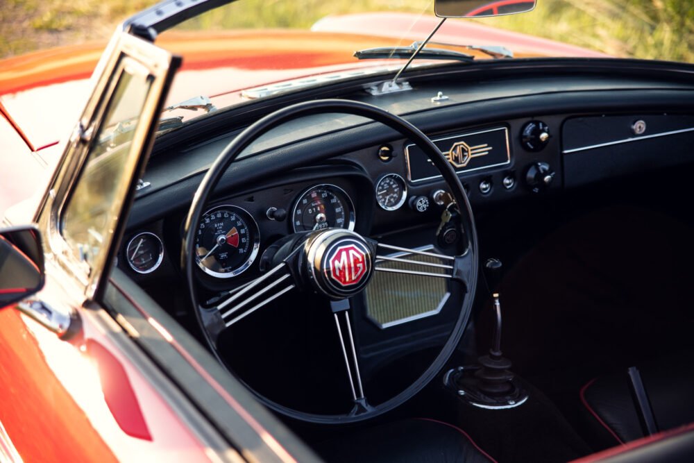 Vintage MG car interior with steering and dashboard.