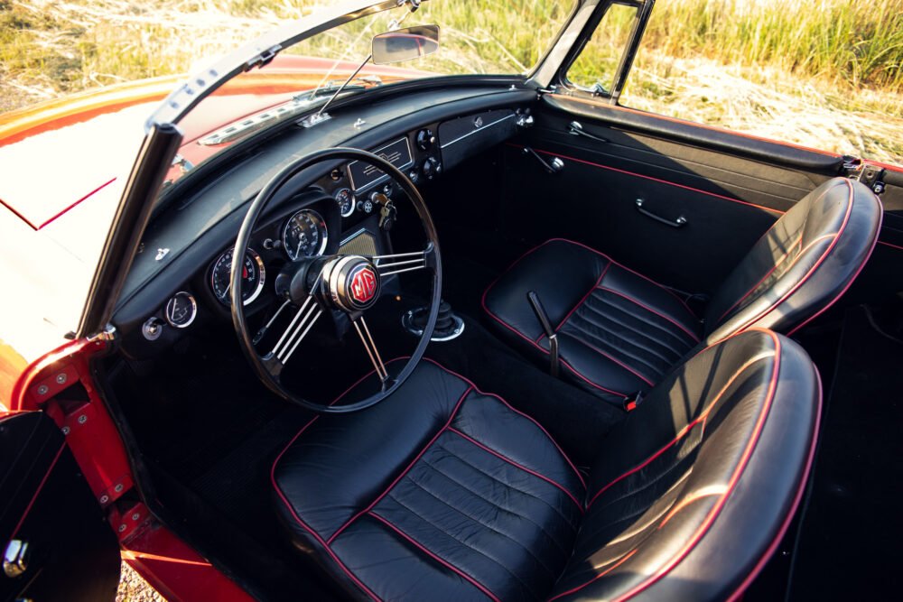Classic red convertible car interior, vintage dashboard and seats.