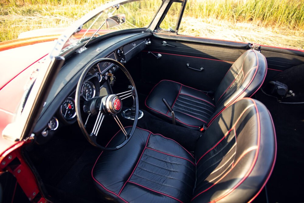 Vintage car interior with red and black leather seats.
