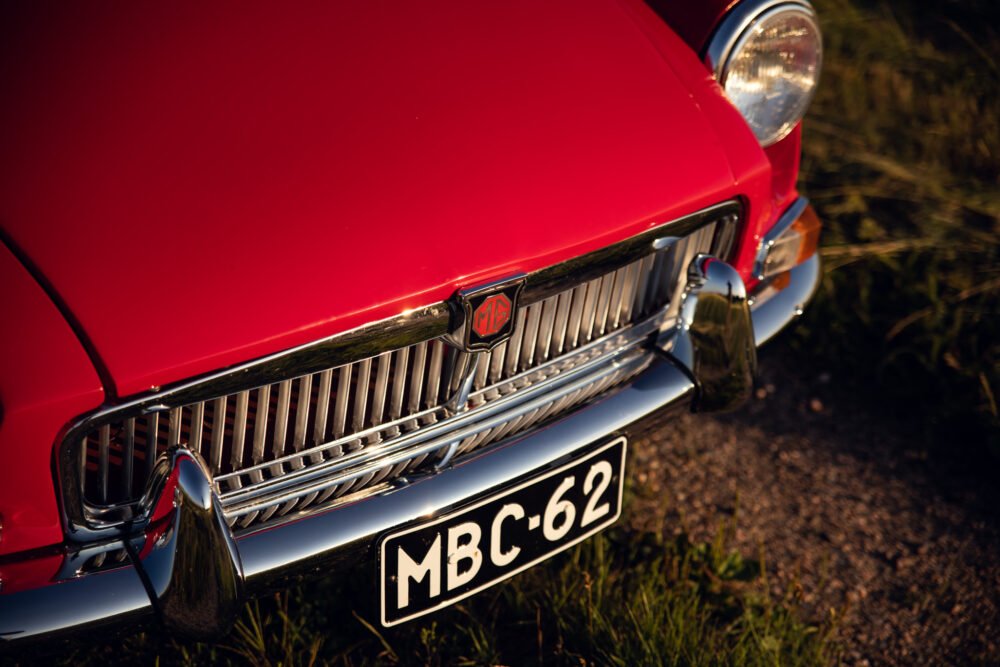 Close-up of red vintage MG car's front grille.