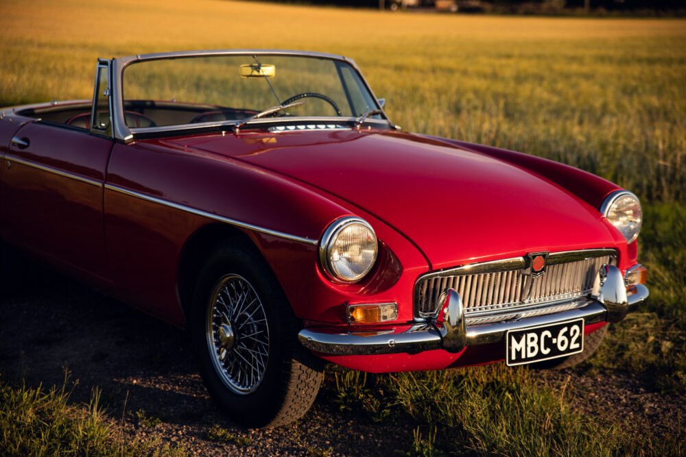 Classic red convertible car in golden field