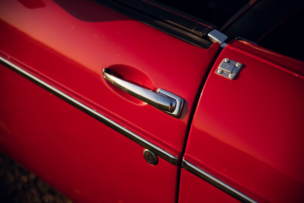 Red car door and handle close-up detail.
