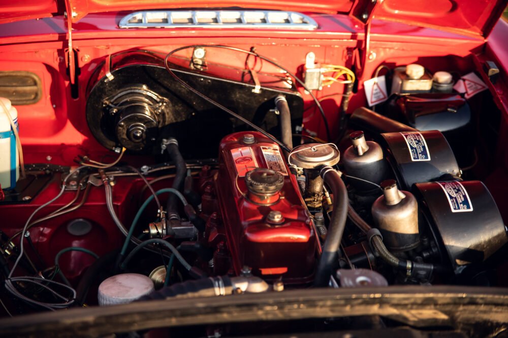 Detailed view of a classic red car engine compartment.