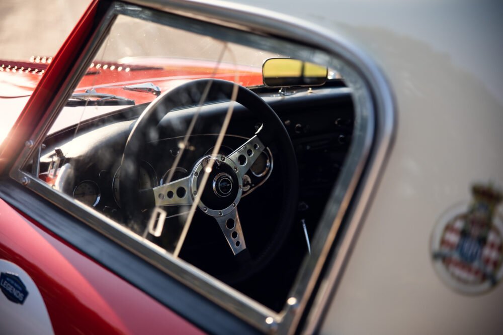 Classic car interior with steering wheel and dashboard.