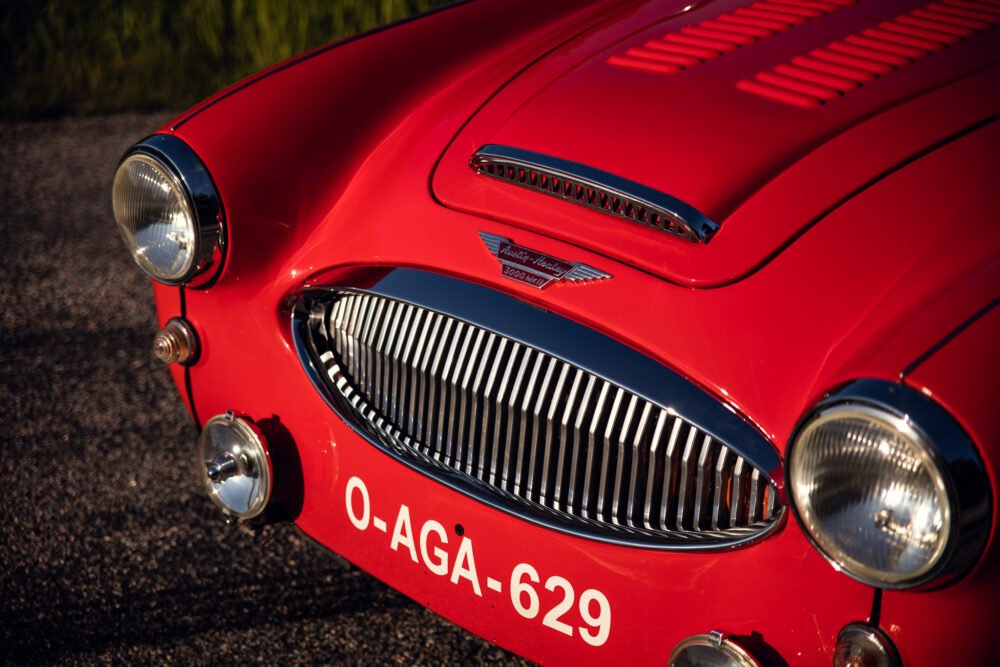 Close-up of vintage red Austin-Healey sports car front.