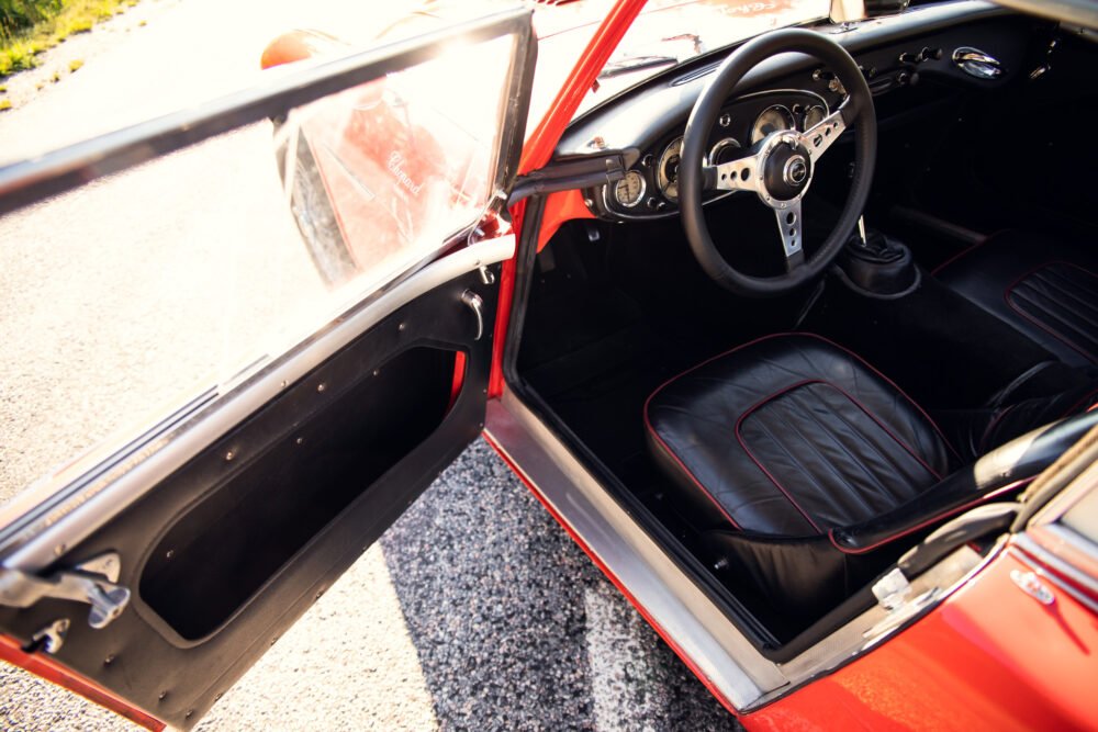 Vintage red car interior with open door.