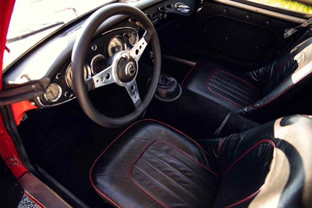 Vintage car interior with black and red leather seats.