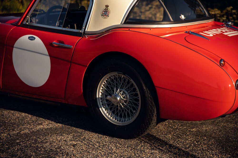 Vintage red sports car with racing number.