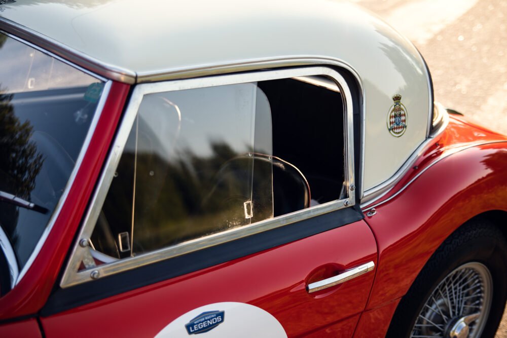 Vintage red car close-up with shiny chrome details.