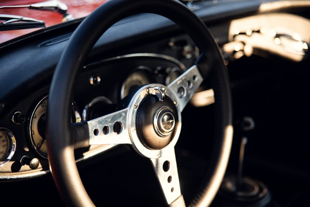 Vintage car's steering wheel and dashboard close-up.