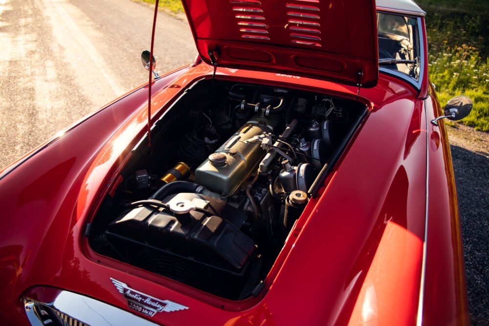 Red Austin-Healey 3000 with open hood showing engine.