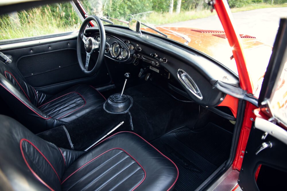 Vintage car interior with black and red leather seats.