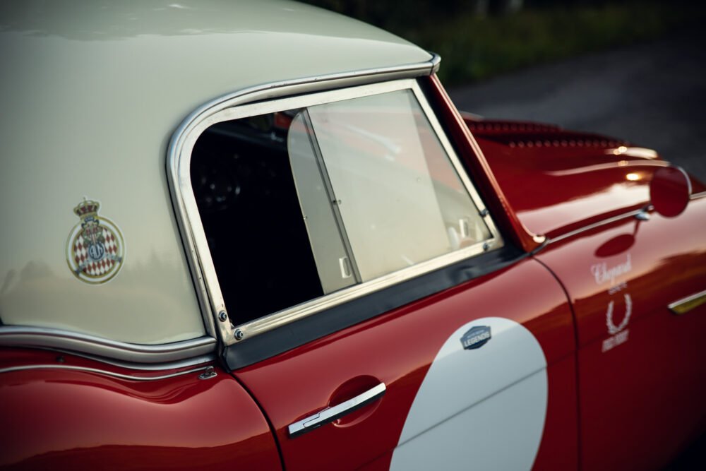 Vintage red car with elegant badge detail.